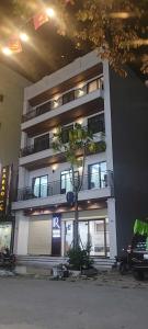 a building with a tree in front of it at R Hotell in Sầm Sơn