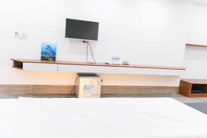 a room with a desk with a tv on a wall at R Hotell in Sầm Sơn +8 photos