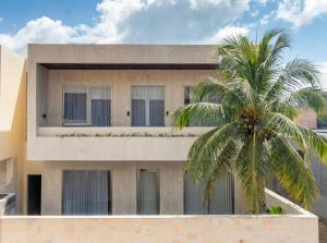 a building with a palm tree in front of it at Surfside Uluwatu Resort in Uluwatu
