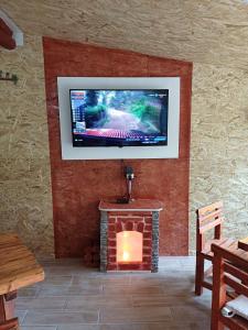 a living room with a fireplace and a television on a wall at Apartman Denis Una in Lužine