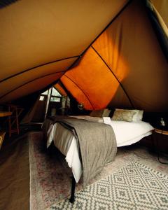 a bedroom in a tent with a bed in it at Bundox Explorer Camp in Hoedspruit