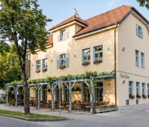 a building with tables and chairs in front of it at Villa Parma in Maribor Self check - in in Maribor