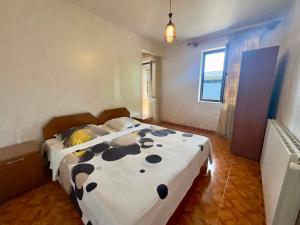a bedroom with a bed with a black and white comforter at Hotel Kobuleti Garden in Kobuleti