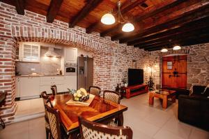a kitchen and dining room with a table and a brick wall at Villa Romantika Dalmacija in Nin