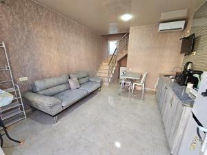 a living room with a couch and a kitchen at Apartment IMERI in Ureki