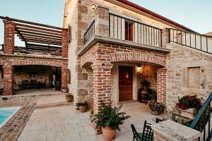 a brick house with a patio and a swimming pool at Villa Romantika Dalmacija in Nin