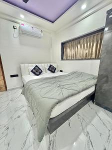 a bedroom with a bed in a room with marble floors at Hotel Siyaram Inn in Trimbak