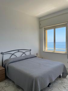 a white bedroom with a bed and a window at Hotel Le Najadi in Santa Marinella
