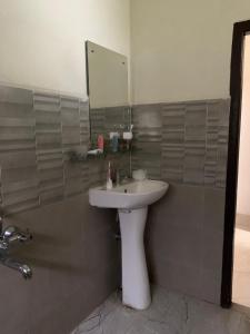 a bathroom with a white sink and a mirror at The 1802 travellers inn in Shillong