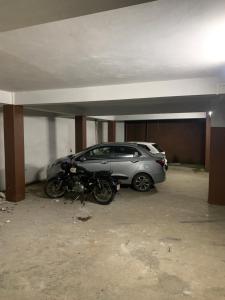 a car and a motorcycle parked in a garage at The 1802 travellers inn in Shillong