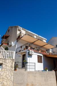 a white house with a balcony and a wall at Apartment Stella in Vis
