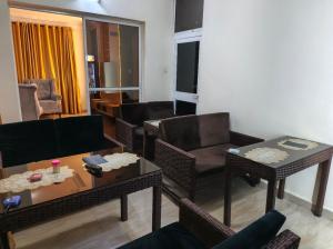 a living room with couches and chairs and a table at Hillmabliz Apartment in Abuja