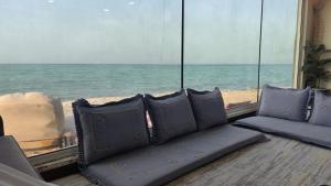 a view of the ocean from a room with chairs at Alwahyada chalet in Majrá al Ghāf