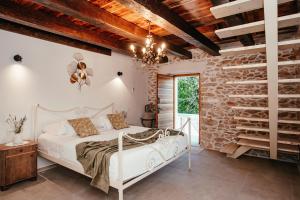 a bedroom with a white bed and a stone wall at Villa Romantika Dalmacija in Nin +36 photos