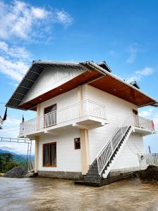 a white building with stairs on the side of it at Sittong Aura in Kurseong