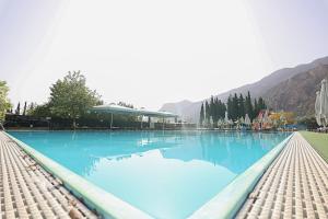 a large pool of blue water with mountains in the background at Semantron Traditional Village in Diakopto +35 photos