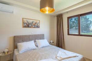 a bedroom with a bed and a window at Agios Ioannis Cozy Houses With Private Pool in Tigaki +24 photos