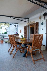 a wooden table with four chairs around it at Apartment Stella in Vis