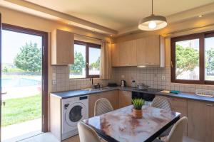 a kitchen with a table and a washing machine at Agios Ioannis Cozy Houses With Private Pool in Tigaki