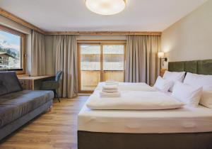 a hotel room with a large bed and a couch at Apartment Gerlos 183 in Gerlos
