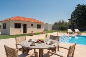a table with a bowl of fruit on it next to a pool at Agios Ioannis Cozy Houses With Private Pool in Tigaki