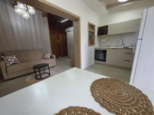 a living room with a couch and a kitchen at הבקתות במושבה in Rosh Pinna