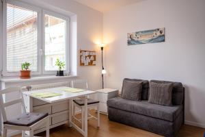 a living room with a couch and a table and a chair at The white Nest Apartment AC & Balcony in Bratislava