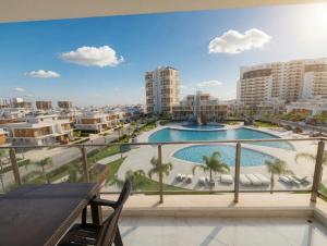 a balcony with a view of a pool and buildings at Long Beach Royal Sun Elite Studio with Pool KKTC in Paralimni