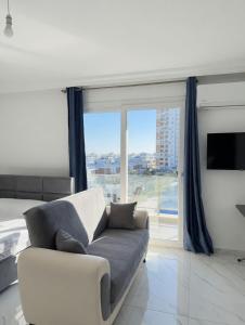 a living room with a couch and a large window at Long Beach Royal Sun Elite Studio with Pool KKTC in Paralimni