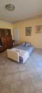 a bedroom with a bed and a couch in it at Dimora Lo Zizzolo - Casa vacanze indipendente vicino Pontedera in Pontedera