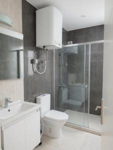 a bathroom with a toilet and a shower and a sink at Long Beach Royal Sun Elite Studio with Pool KKTC in Paralimni