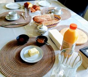a table with plates of food and a bottle of orange juice at Villa Tronçais in Saint-Bonnet-Tronçais