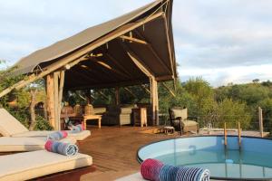 a pavilion with a hot tub on a wooden deck at Bundox Explorer Camp in Hoedspruit