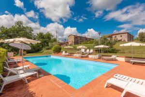 a swimming pool with lounge chairs and umbrellas at Relax nella jacuzzi in Toscana in Colle di Val d'Elsa