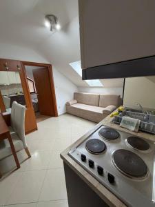 a kitchen with a stove top oven next to a living room at Apartments Šoić in Samobor