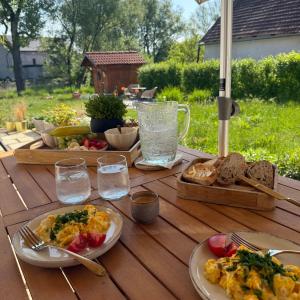 a wooden table topped with plates of food and bread at Chalupa jako domov in Kolín +10 photos