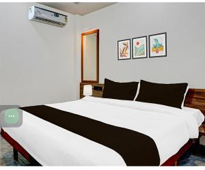 a bedroom with a white bed with black pillows at Hotel sai laxmi residency in Lonavala