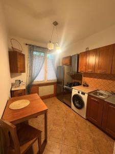 a kitchen with a table and a stove and a washing machine at Mieszkanie w Centrum Hajnówki-Brama Puszczy Białowieskiej in Hajnówka