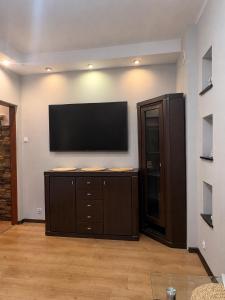 a living room with a flat screen tv on a wall at Mieszkanie w Centrum Hajnówki-Brama Puszczy Białowieskiej in Hajnówka