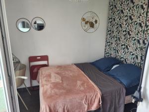 a small bedroom with a bed and two mirrors at Studio cosy sans vis-à-vis in Vernon