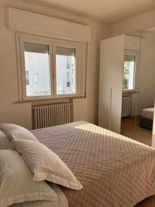 a bedroom with a bed and two windows at LatinaStreet Apartament in Riccione