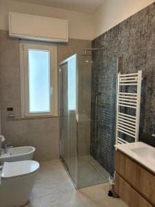 a bathroom with a shower and a toilet and a sink at LatinaStreet Apartament in Riccione