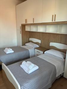 two beds in a room with white towels on them at LatinaStreet Apartament in Riccione +8 photos