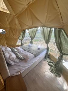 a bed in a tent with a window at Glamping Izerska Bajka in Mirsk