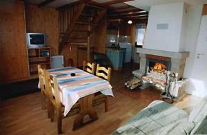 a living room with a table and a fireplace at Leśna Polana in Baligród