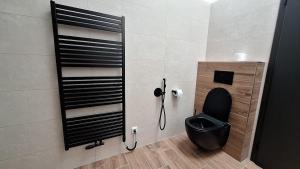 a bathroom with a toilet with a black seat at Thomas home in Homole +10 photos