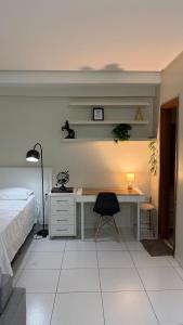 a bedroom with a desk and a bed at Santorini Piscina Hidro Academia Salt Hospital Premium Jaime Câmara Mercatto Store Moreira Marista Blue Fit Perdomo Vaca Brava Goiânia Shopping Areião Marista Ze Abílio Serrinha Campo do Goiás Hailé Pinheiro in Goiânia
