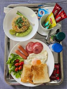 two plates of breakfast food on a tray at TEAK VILLA in Bangna