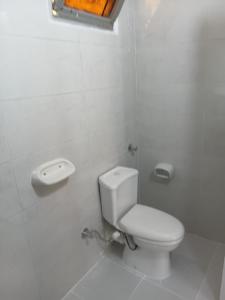 a white bathroom with a toilet and a window at City Hotel in Luxor +9 photos