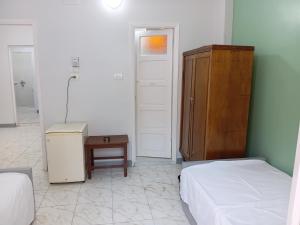 a bedroom with two beds and a cabinet and a table at City Hotel in Luxor